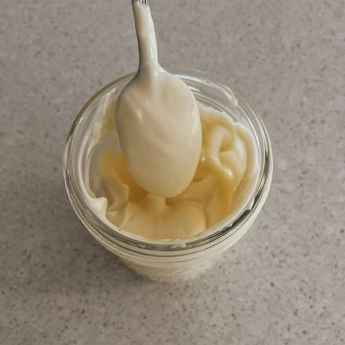 top view of easier and healthier homemade mayo in a glass mason jar with spoon