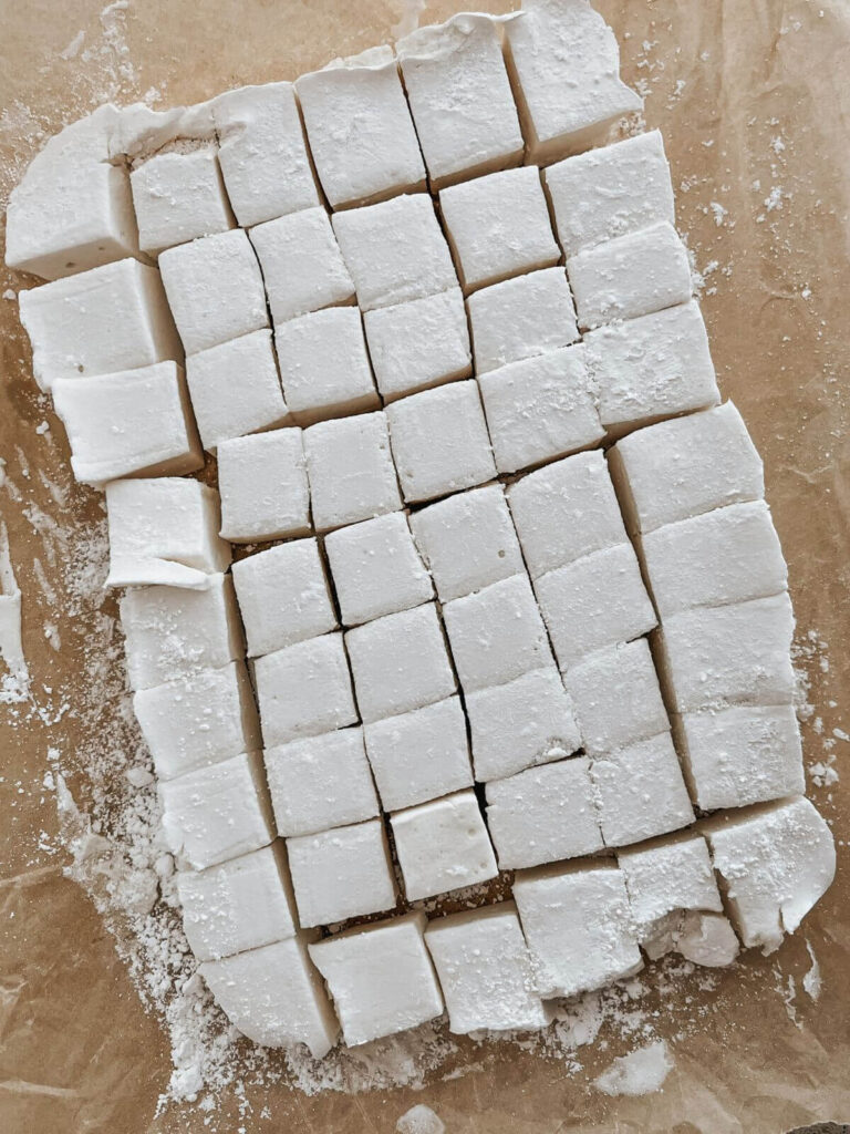 marshmallows cut in squares on parchment paper