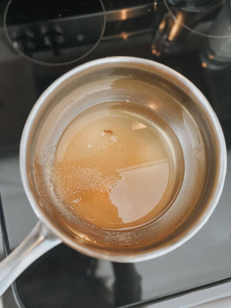 cane sugar and water in a stainless steel bowl heating 