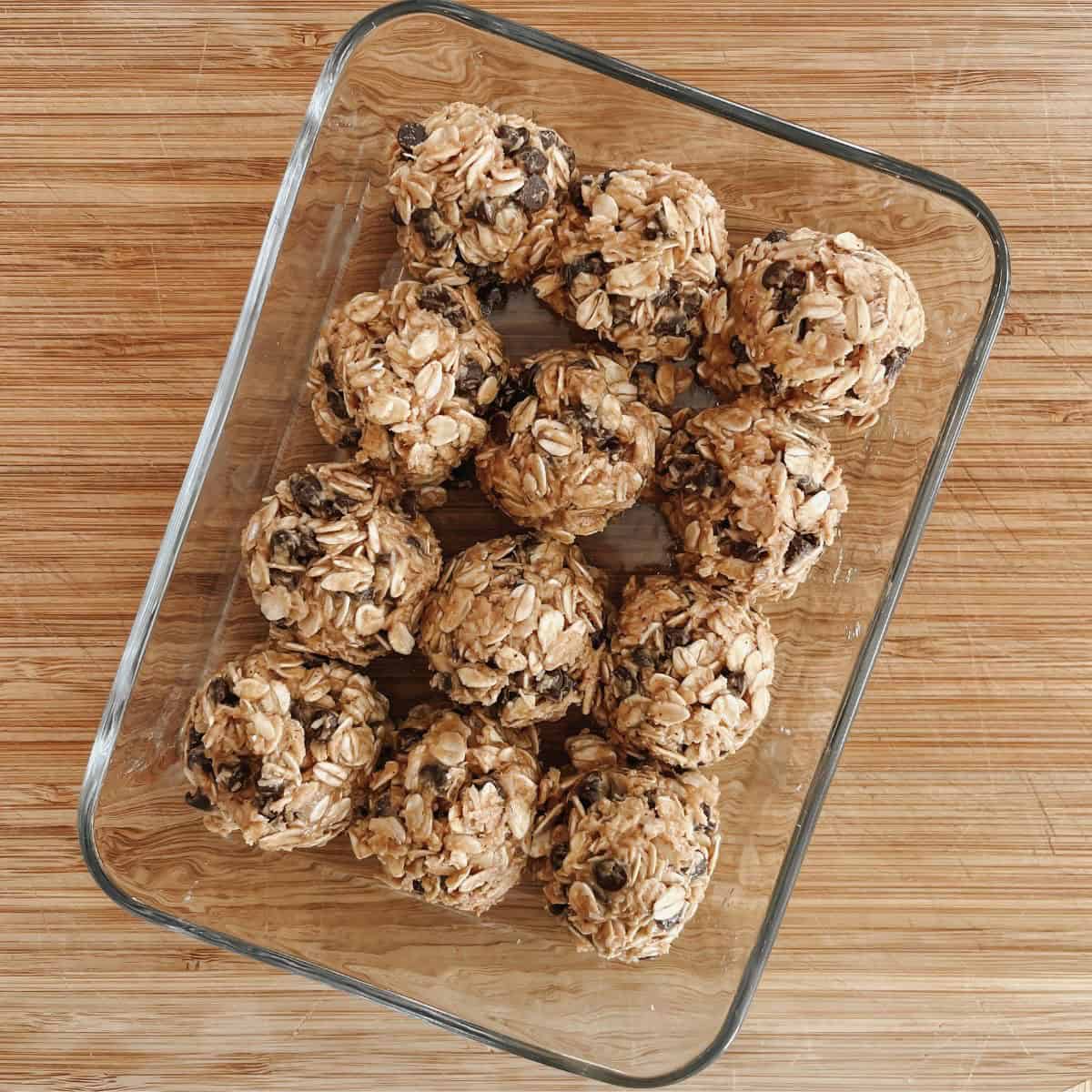 12 5-Ingredient Energy Balls in a glass container on a cutting board