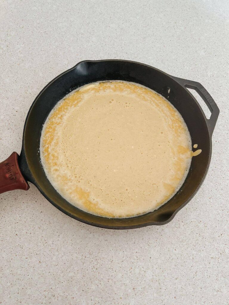 batter for the pancake in a cast-iron pan ready to bake