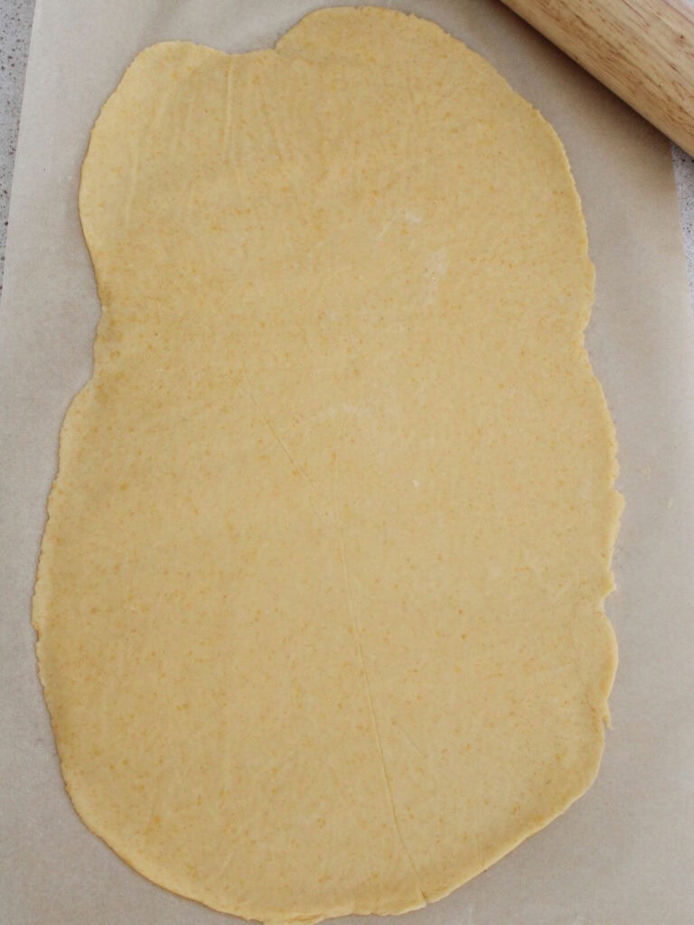 The dough rolled out on parchment paper 