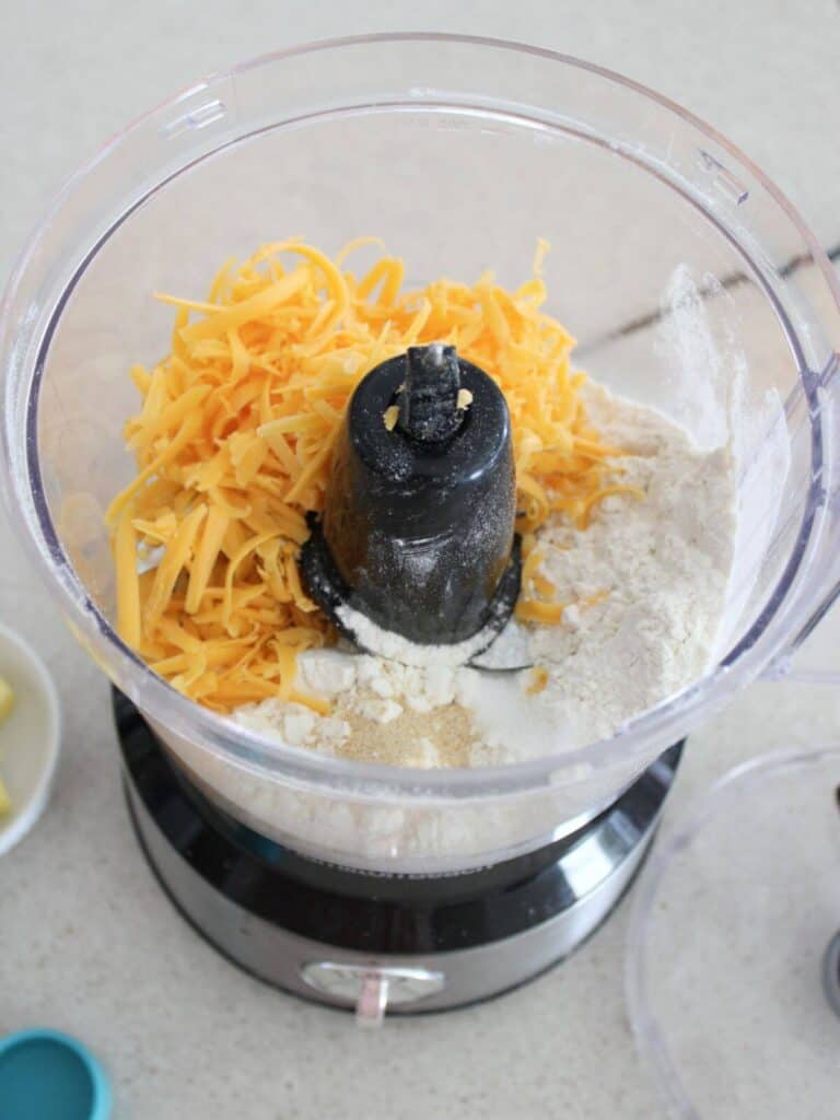 Cheese, flour, salt and garlic powder ready to be pulsed in the food processor. 