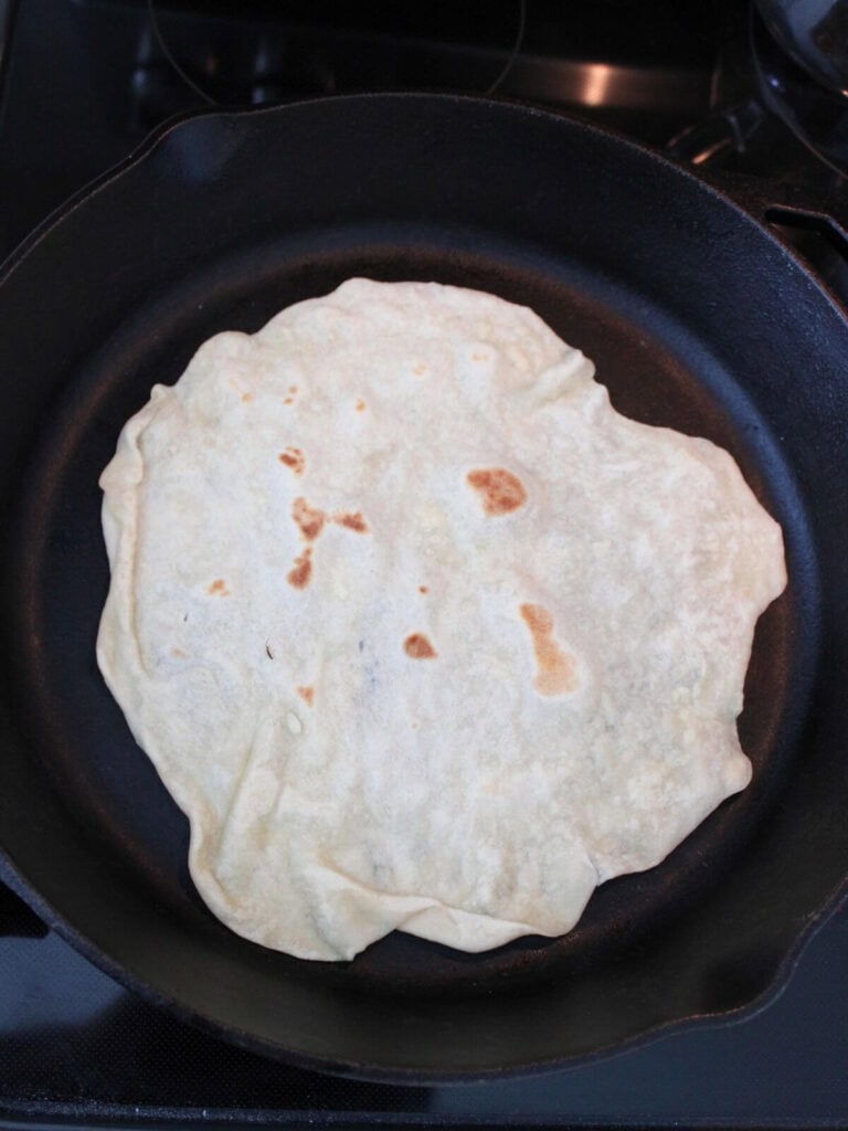 Tortilla cooking in a cast-iron pan 